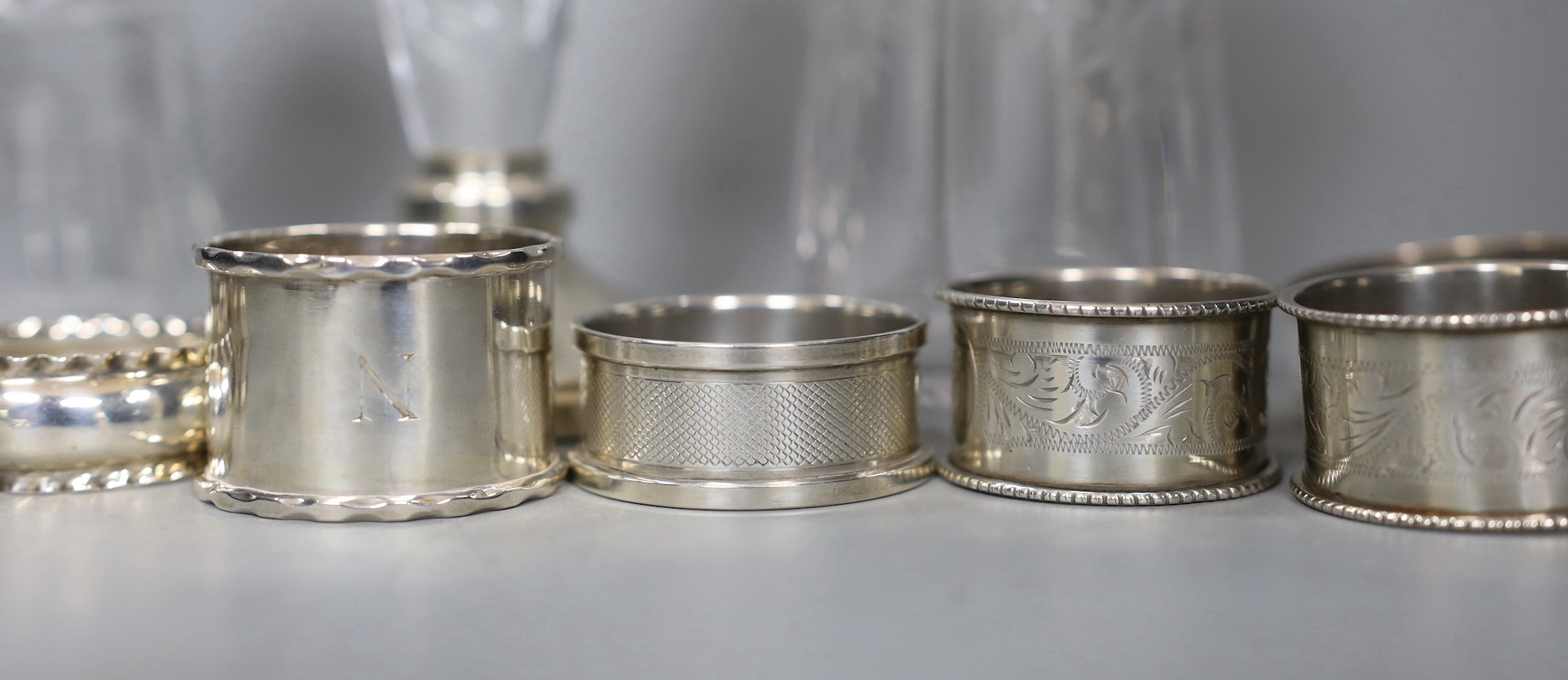 A pair of George V silver napkin rings, Birmingham, 1926, six other silver napkin rings and one stamped 'Silver', a 196's silver handled cake slice, two silver mounted glass sugar sifters and a silver mounted glass posy